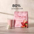 Juice Plus+ Complete Nutrition Shake Mix package with a glass of shake and strawberries on a light background