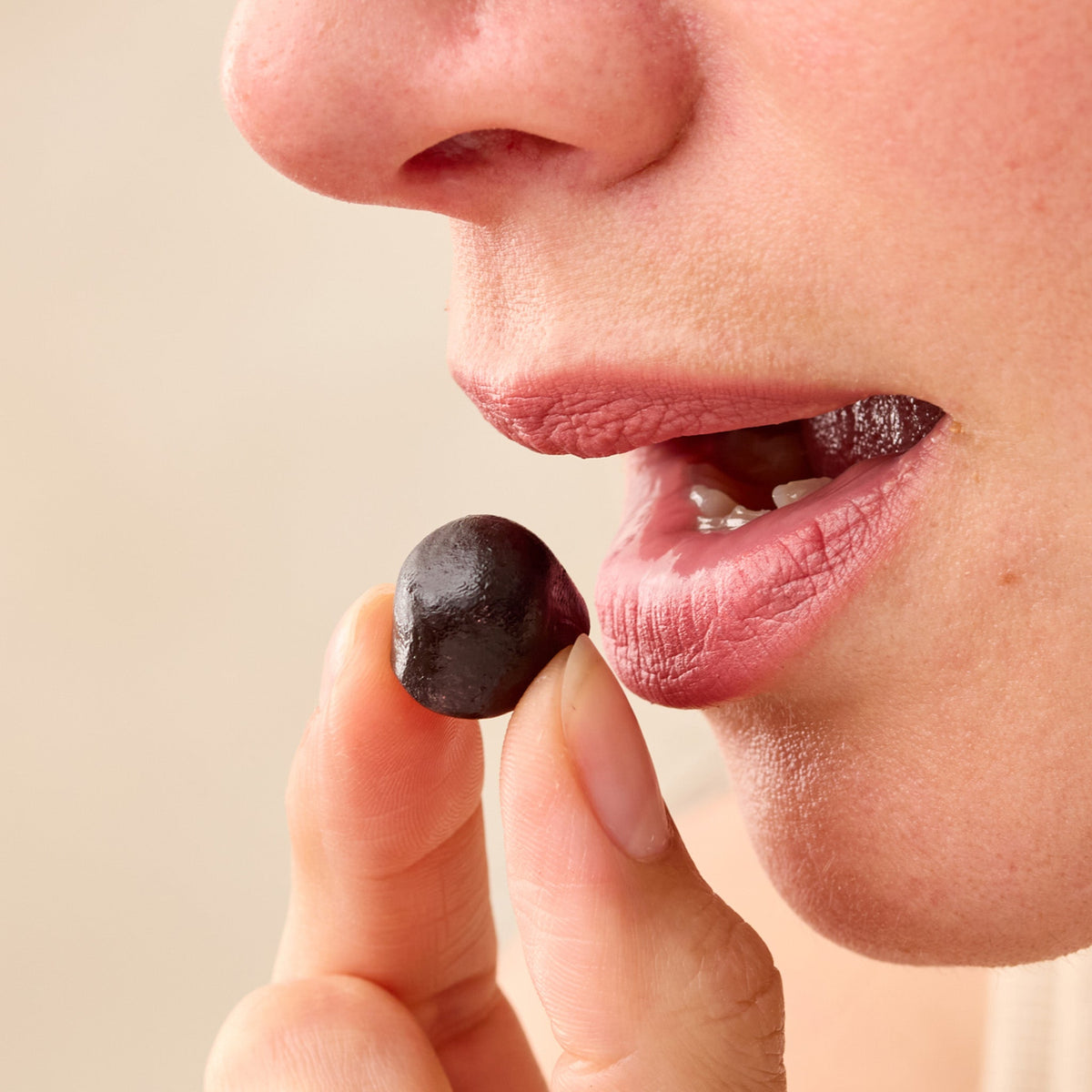 Close-up of a person holding and about to eat a Juice Plus+ Chewable.