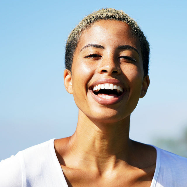 Woman smiling with a clear blue sky background